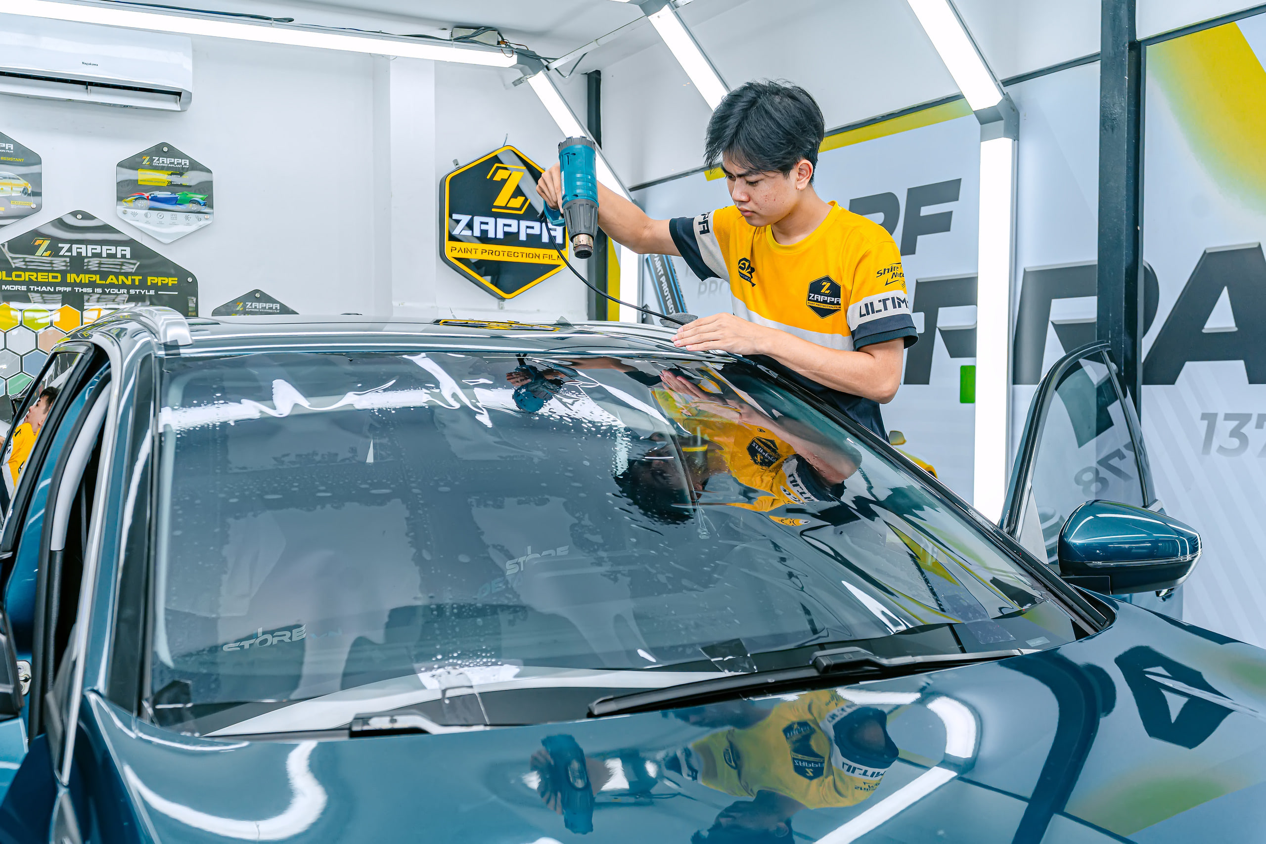 Kỹ thuật viên khò phim cách nhiệt kính lái Peugeot 5008 tại Store Detailing Tân Phú